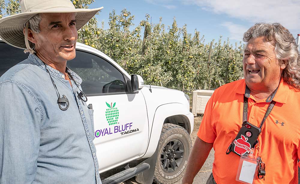 Craver habla sobre la cosecha con Juan Ojeda, gerente de una granja y uno de sus muchos empleados de toda la vida, en el huerto de New Royal Bluff Orchards. Los dos han trabajado juntos durante 22 años. (TJ Mullinax/Good Fruit Grower)