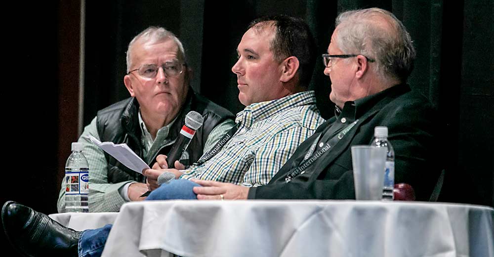 Guiados por Tom Auvil, izquierda, Travis Allan, centro, y Don Gibson hablan sobre varios desafíos que enfrentan los productores de fruta de árbol durante el primer día de la Reunión Anual de la Asociación de Árboles Frutales del Estado de Washington en diciembre en Wenatchee, Washington. (TJ Mullinax/Good Fruit Grower)