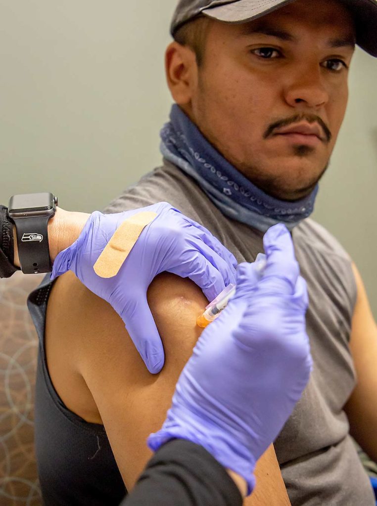 González recibe su pinchazo en el brazo por parte de la asistente médica de la Asociación de Salud de la Cuenca del Río Columbia, Alma Álvarez. (Ross Courtney/Good Fruit Grower)