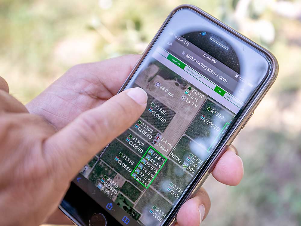 Edgar Escobar muestra cómo la aplicación para un teléfono móvil de Ranch Systems lo mantiene al día con los programas de irrigación, aunque no había ninguna programada, ya que el agua de riego se agotó unas semanas antes de la cosecha. (TJ Mullinax/Good Fruit Grower)