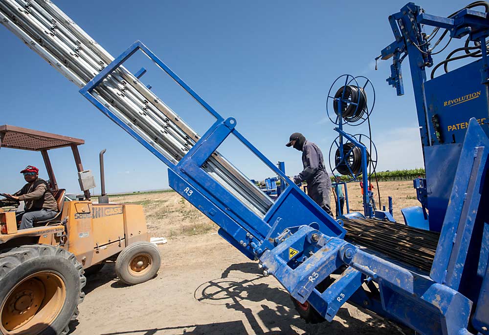 La máquina puede transportar varios estilos de estacas y postes simultáneamente, aunque el proceso puede complicarse en los casos de diseños complejos de las espalderas. (TJ Mullinax/Good Fruit Grower)