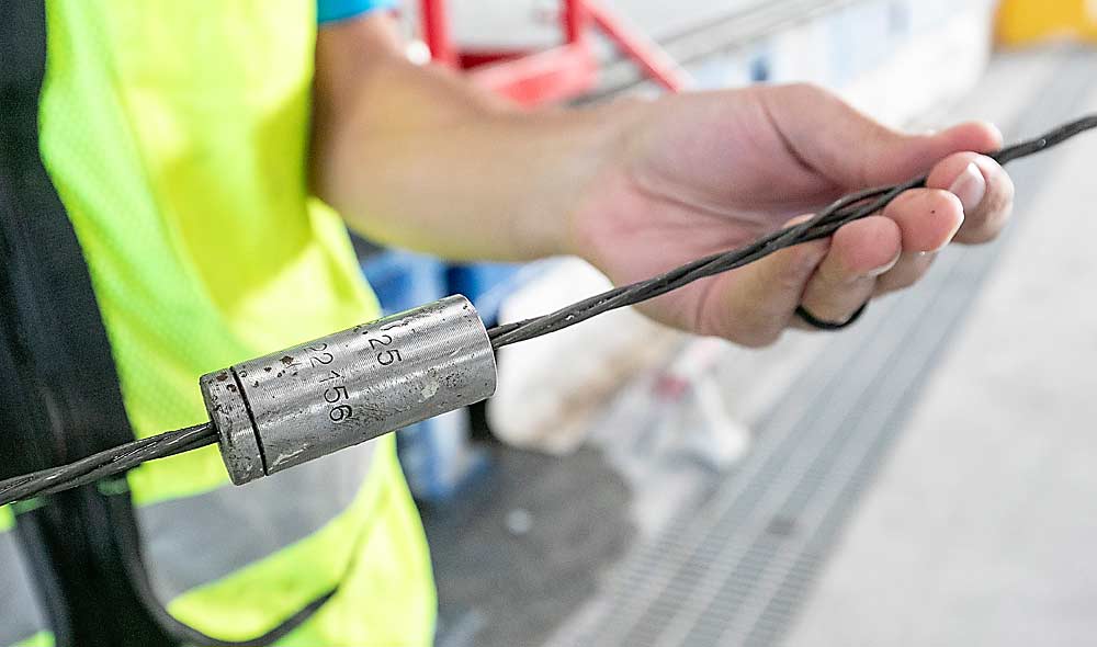 La maquinaria utiliza este cilindro pequeño para estirar (pretensar) los cables de acero trenzado hasta 18 pulgadas más allá de los moldes de 240 pies. Después de que se cura el concreto, los cables retroceden a su tamaño original lo cual proporciona resistencia y flexibilidad. (TJ Mullinax/Good Fruit Grower)