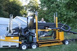Chuck Dietrich demonstrates the hydraulically powered device that levels the platform so workers perform better on sloping ground.