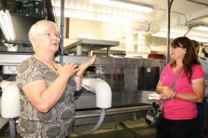 Christine Dendy (left) shows Debbie Becker and an international group of cherry industry people around her packing house at East Kelowna. 