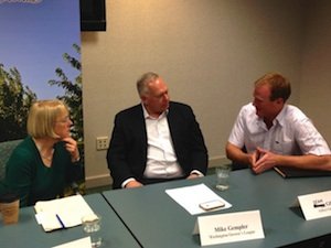 Sean Gilbert of Gilbert Orchards, right, speaks to Sen. Patty Murray, left, as Mike Gempler of the Washington Growers League listens. 