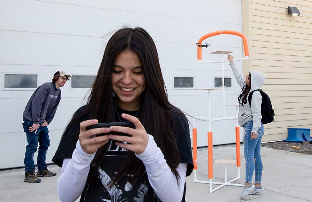 Bravo laughs as Barrera and Schrader guide her drone oh-so-close to her target. (Ross Courtney/Good Fruit Grower)