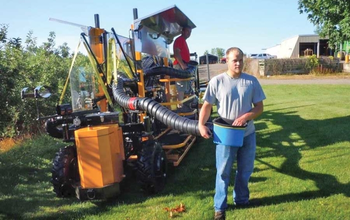 Andrew Duffy, a Phil Brown Welding employee, demonstrates the DBR Conveyor’s new pivoting, plastic bucket, designed to reduce worker strain. (Courtesy Phil Brown Welding)