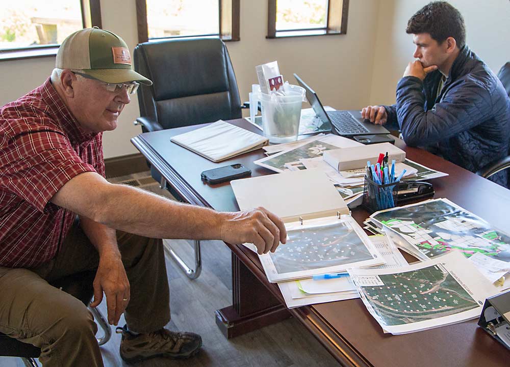 Mark LaPierre, left, an orchard manager for FirstFruits Farms in Prescott, Washington, discusses how he and his son, Garrett, right, increase trap density along ridge lines, where moth pressure tends to increase. (Ross Courtney/Good Fruit Grower)