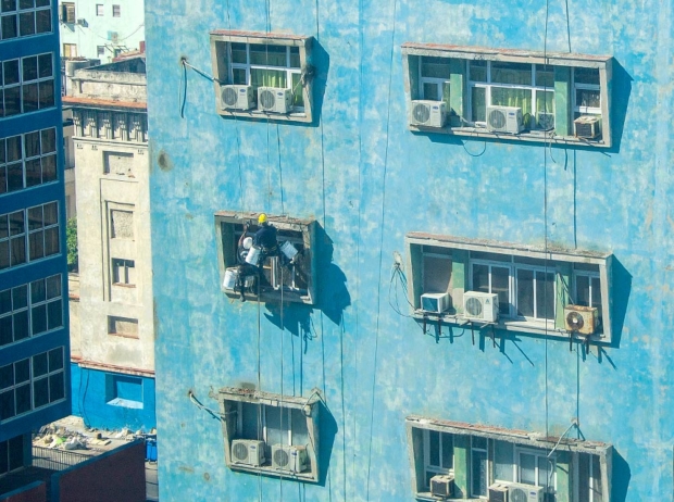 Two men work on a window repair in downtown Havana. It’s not uncommon to see crews working without any power tools. In Cuba’s socialist state, the goal is full employment not efficiency. (O. Casey Corr/Good Fruit Grower)