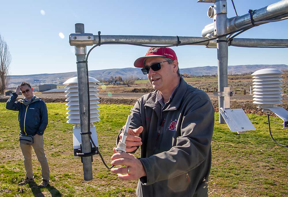 Sean Hill, right, of AgWeatherNet discusses an air and relative humidity sensor on WSU’s station at a March field day while Jason Navarette of Allan Bros. listens. (Ross Courtney/Good Fruit Grower)