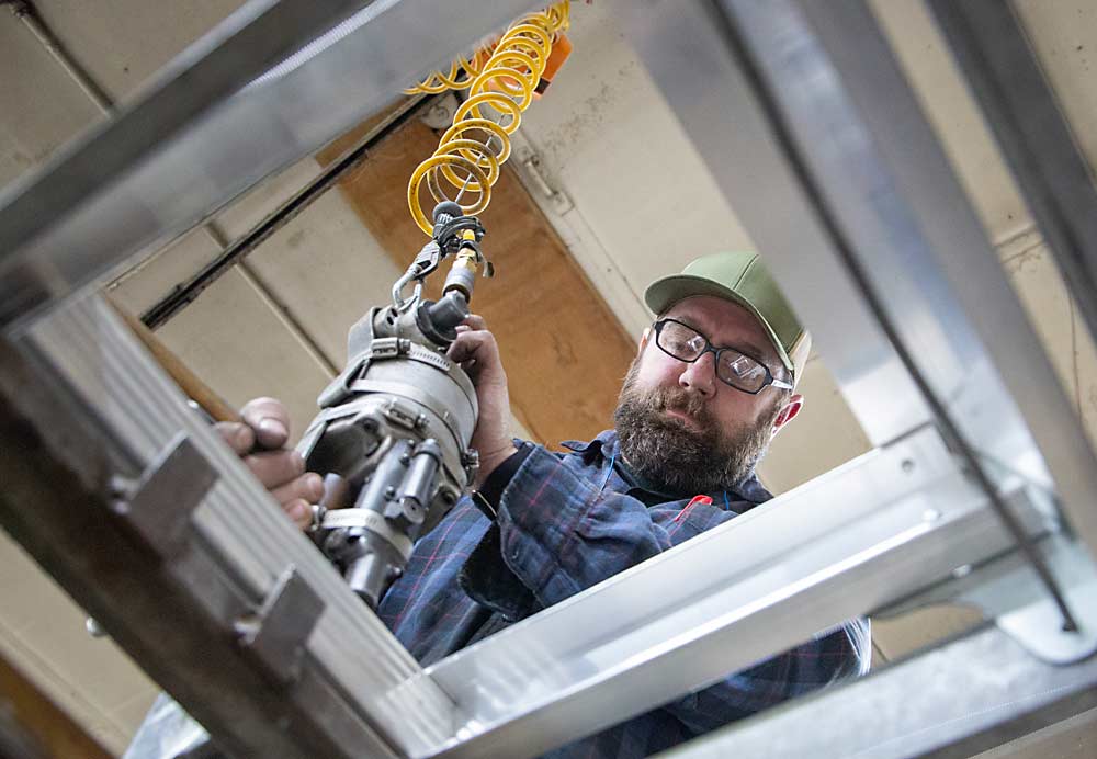 Brad Nieman fastens rivets on a new 10-foot ladder in March at his Dependable Ladder business in Yakima, Washington. (Ross Courtney/Good Fruit Grower)