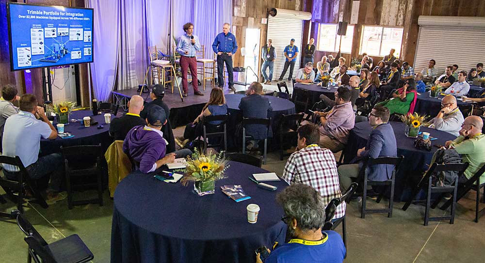 Meiko Martin, left, and Mike Dentinger of Trimble share some of the mapping technology company’s story at one of several pitch sessions at FIRA, designed for growers, investors and other startups to witness. (Ross Courtney/Good Fruit Grower)