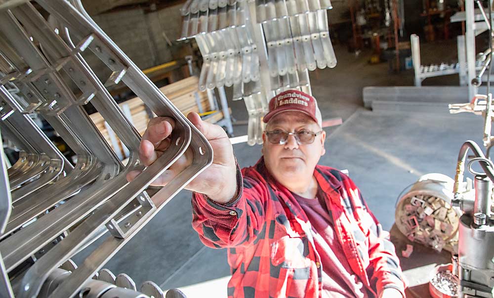 Richard Shenyer, owner of Grandview Ladders in Washington, shapes and assembles top brackets by hand. Ladder demand has stayed steady despite the increasing use of platforms in the past 20 years, he said. (Ross Courtney/Good Fruit Grower)