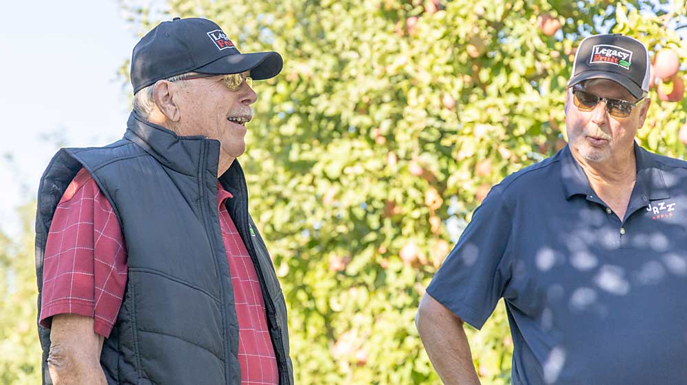 Noe(왼쪽)가 재배자 Mike Van Horn과 함께 10월에 Van Horn의 Zillah 지역 과수원에서 이 유기농 Fujis의 첫 번째 수확 시기에 대해 이야기합니다.  (Kate Prengaman/Good Fruit Grower)