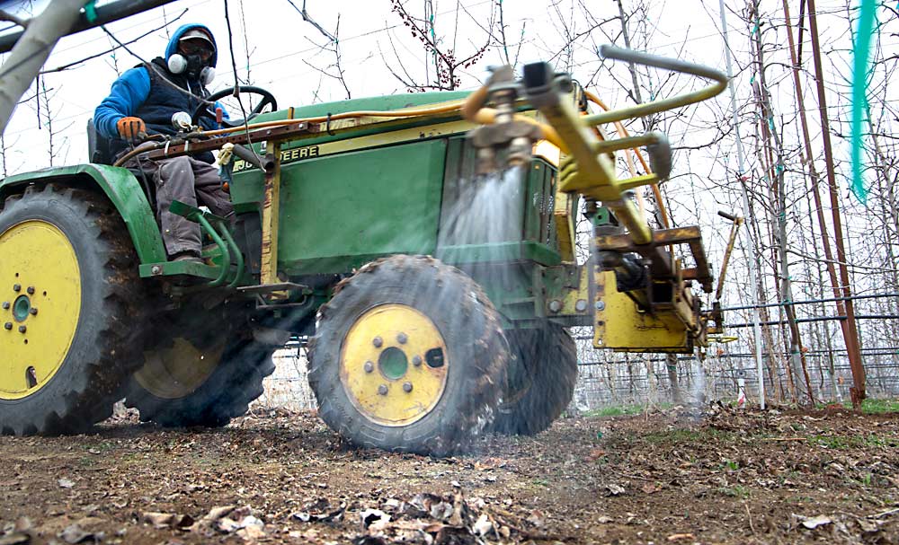 Leonardo Enriquez applies a preemergent herbicide in a block of WA 38 apples in March in Washington’s Yakima Valley. (Ross Courtney/Good Fruit Grower)