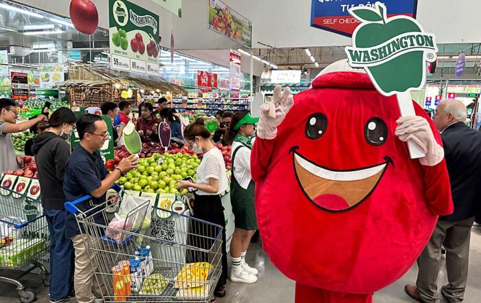 A Washington Apple Commission mascot greets shoppers in the produce section of the MM Mega Market during a promotional event on April 11. Vietnam is the fifth largest export market for Washington apples, according to the commission. (Courtesy Washington State Department of Agriculture)