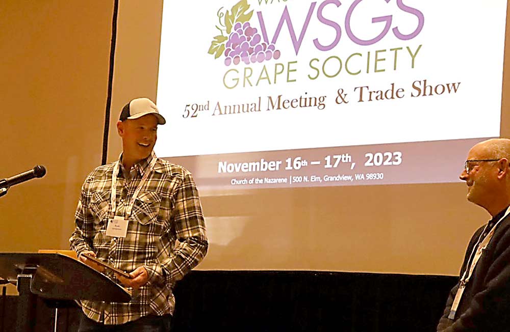 Grower Ryan Schilperoort accepts the Washington State Grape Society’s Lloyd H. Porter Grower of the Year Award from society present Keith Oliver, at right. (Kate Prengaman/Good Fruit Grower)
