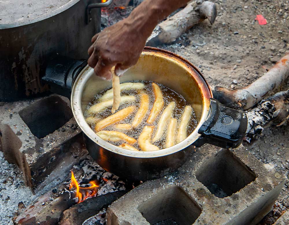 Festival dumplings, fried dough flavored with cinnamon, bubble over an open fire. (Ross Courtney/Good Fruit Grower)