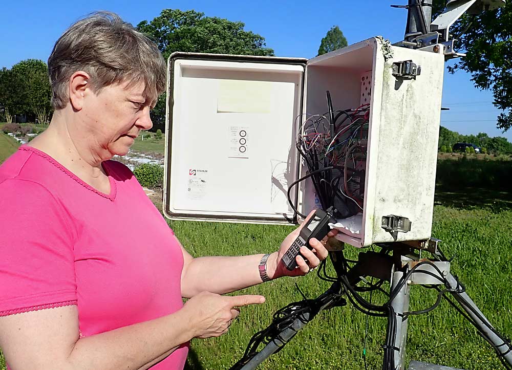 Pam Knox, agricultural climatologist and director of the University of Georgia weather network, makes a stop at Durham Horticulture Farm’s weather station, one of the 88 weather stations scattered around the state. Georgia is experiencing increasingly warm winters, which is one of the reasons for the peach problems this year. (Leslie Mertz/For Good Fruit Grower)