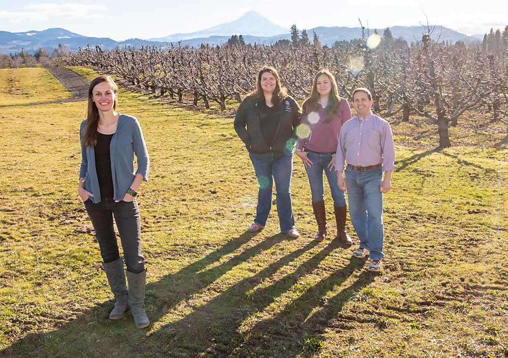 The team at the Mid-Columbia Research and Extension Center in Hood River, Oregon, is back at full strength. From left, U.S. Department of Agriculture’s Rachel Leisso filled a new position late last year, joining Oregon State University’s Ashley Thompson, Kelsey Galimba and Chris Adams. Mount Hood is in the background. (Ross Courtney/Good Fruit Grower)