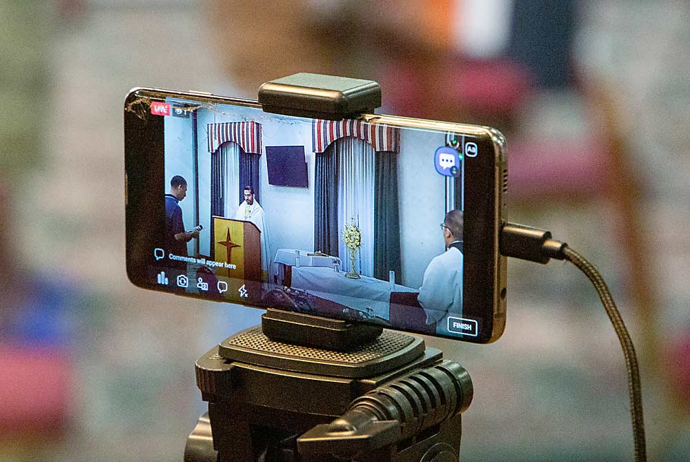 A seminary student broadcasts the service live for family members in Mexico to watch and follow. (Ross Courtney/Good Fruit Grower)