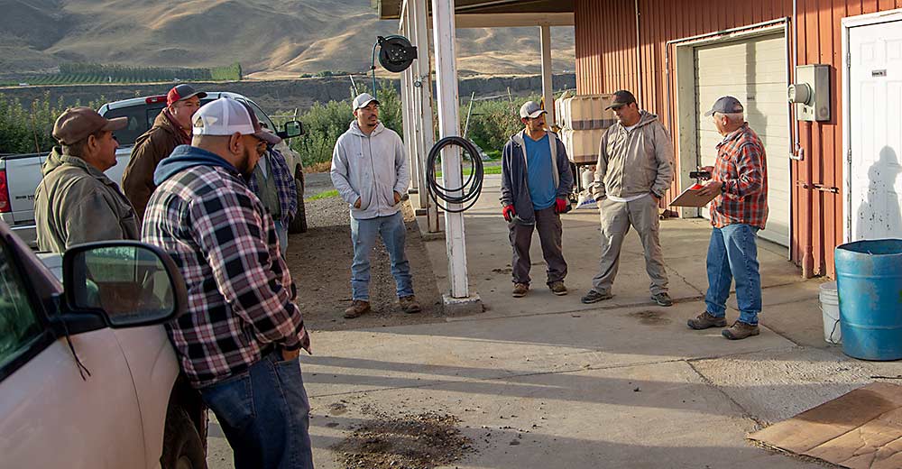 River Valley Orchards’ Lupe Muñoz, right, leads a safety meeting in October in Benton City, Washington, with year-round, full-time employees who expect to need second jobs to make ends meet as the state’s overtime mandates phase in. Good Fruit Grower has interviewed workers in Washington and California over the past year about the loss of agricultural overtime exemptions. (Ross Courtney/Good Fruit Grower)