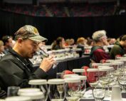 Gerardo Cambron, cellar lead for Col Solare winery, sniffs a glass of sparkling Grosgrain Vineyards 2022 Lemberger Blanc de Noir on Feb. 7 during the Grand Tasting at WineVit, the annual convention of wine grape growers, at the Toyota Center in Kennewick, Washington. (Ross Courtney/Good Fruit Grower)