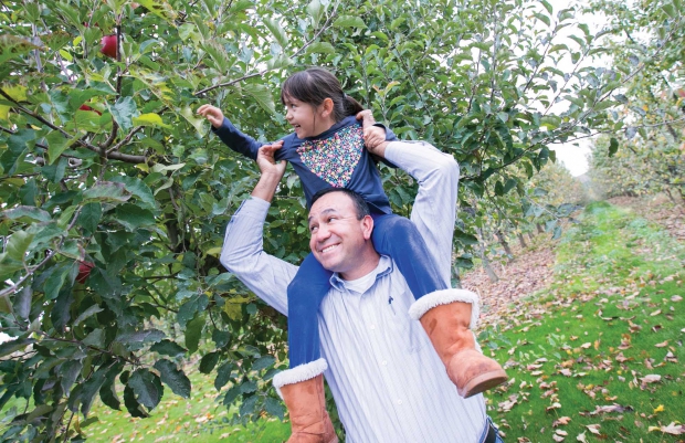 José Ramirez, from Stein Manzana Orchards, with his 6-year-old daughter Rosa Lynn standing in front of the first apple tree of the same name at his orchard near Royal City, Washington on November 03, 2014. (TJ Mullinax/Good Fruit Grower)