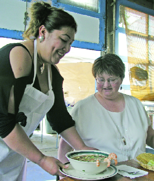 Florinda Puebla serves Caldos de Mariscos (Seafood Stew) to Nanette Lee, with Lee’s special request granted: “No pulpo, por favor.” (No octopus, please.)  (Photo by Jim Black)