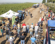 A crowd of well over 100 people circle around Washington State University’s Bernardita Sallato discussing nutrient optimization during a field day on Aug. 2, at the Smart Orchard near Grandview, Washington. (Ross Courtney/Good Fruit Grower)