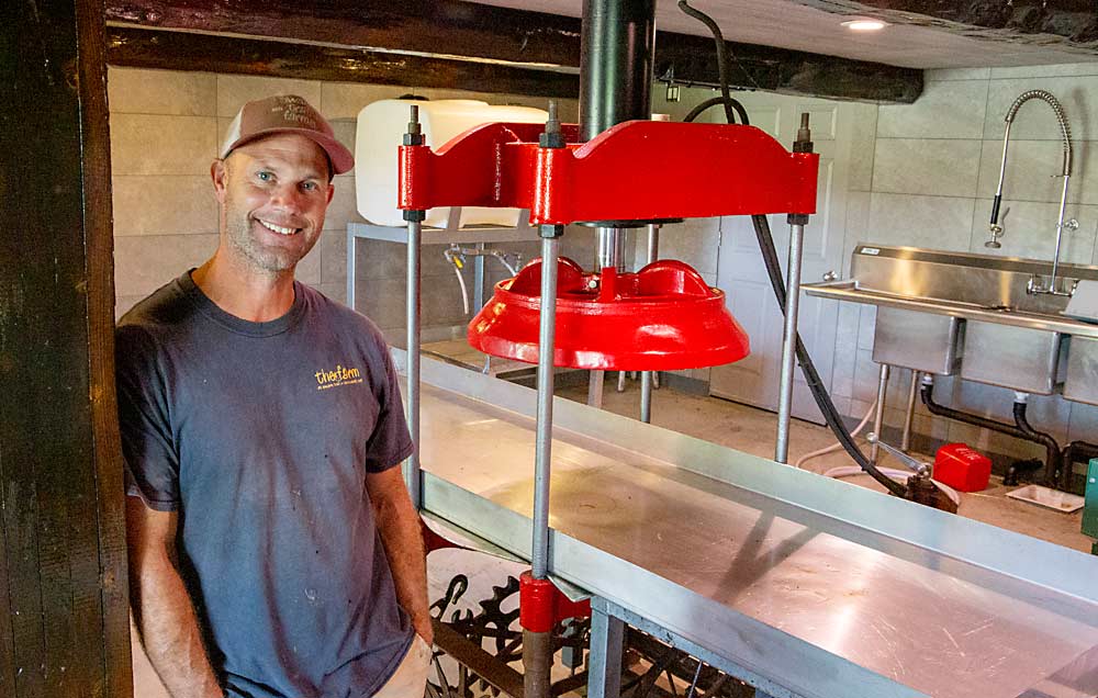 Krause poses next to his fresh apple cider press, one of the calling cards for the Swans Trail agritainment venue. The 5G Open Innovation Lab aims to also set up test sites in wholesale specialty crop farms in Eastern Washington. (Ross Courtney/Good Fruit Grower)