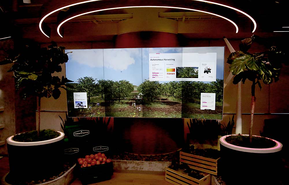 A panoramic screen shows a smart, robotic apple-picking arm attached to a driverless ATV at the 5G&me interactive tour at T-Mobile’s Bellevue, Washington, corporate office, showcasing what the company imagines improved connectivity can offer the world. (Ross Courtney/Good Fruit Grower)