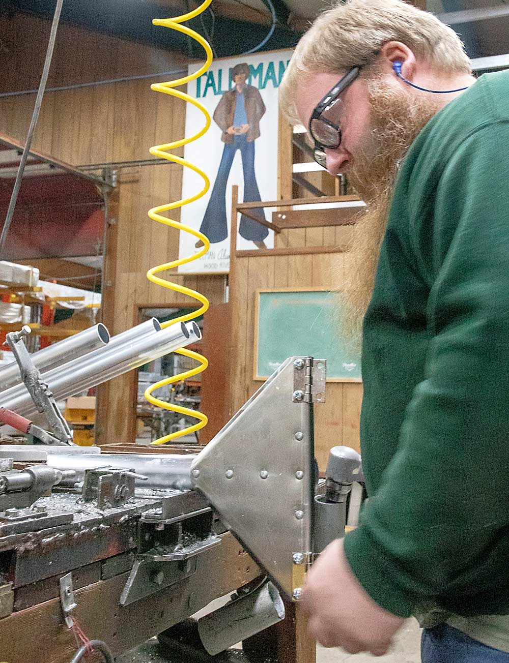 Under the watchful gaze of the Tallman mascot, foreman David Stolhand builds the top braces for orchard ladders. (Ross Courtney/Good Fruit Grower)