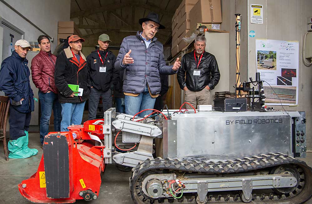 볼로냐 대학의 원예학자인 Luca Corelli Grappadelli는 IFTA 투어 참석자들에게 Field Robotics 무인 트랙터의 초기 프로토타입을 보여줍니다.  (로스 코트니/좋은 과일 재배자)