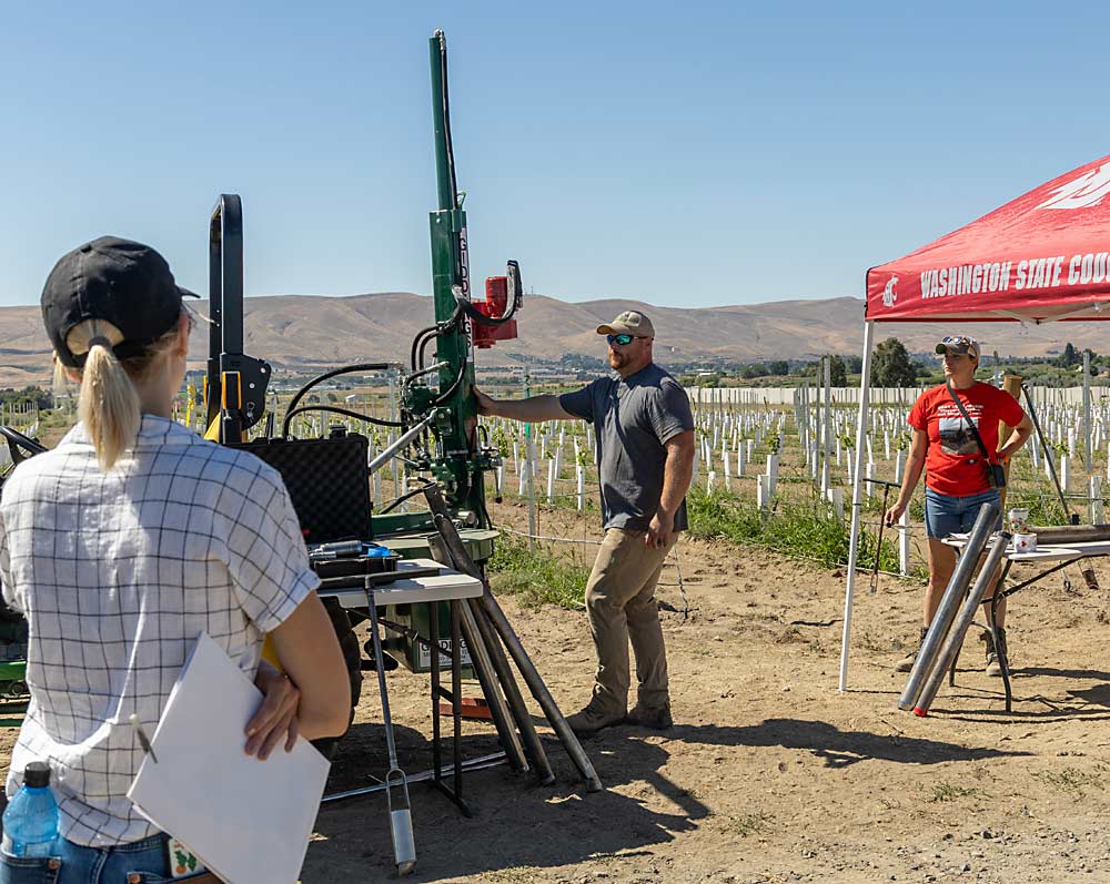 During an August field day hosted by the Washington State Grape Society, soil scientist Liz Gillispie (right) and technician Brandon Peterson explain how they sample deep soil cores for analysis.  (Kate Prengaman/Good Fruit Grower)