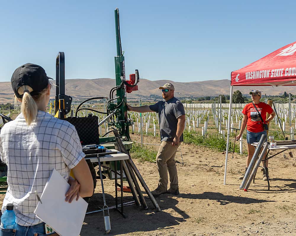 During an August field day organized by the Washington State Grape Society, soil scientist Liz Gillispie, right, and technician Brandon Peterson explain how they take deep soil core samples for analysis. (Kate Prengaman/Good Fruit Grower)