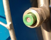A chipped and worn ceramic spray nozzle