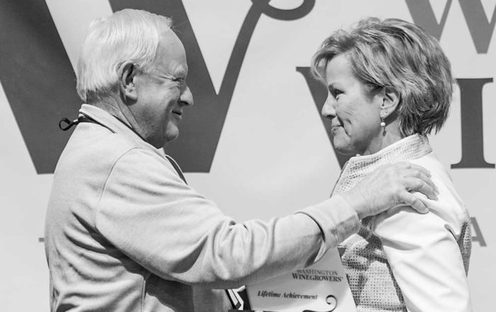 Mike Sauer, left, receives the 2019 Lifetime Achievement award from executive director Vicky Scharlau, right, during the Washington Winegrowers luncheon on March 5 in Kennewick. (TJ Mullinax/Good Fruit Grower)