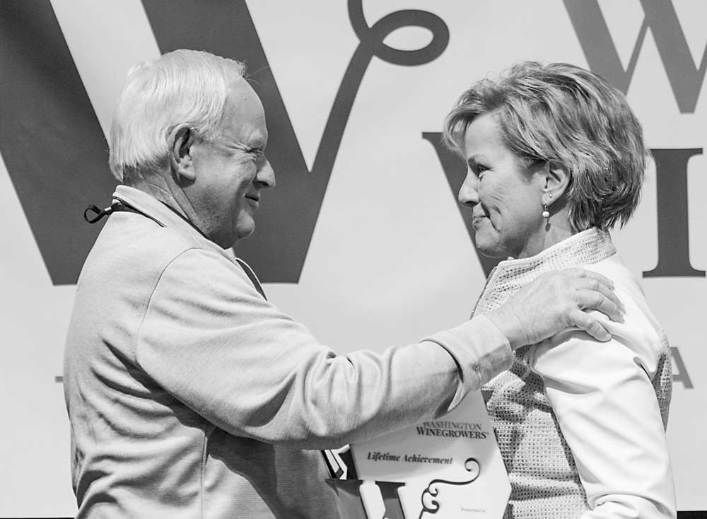 Mike Sauer, left, receives the 2019 Lifetime Achievement award from executive director Vicky Scharlau, right, during the Washington Winegrowers luncheon on March 5 in Kennewick. (TJ Mullinax/Good Fruit Grower)