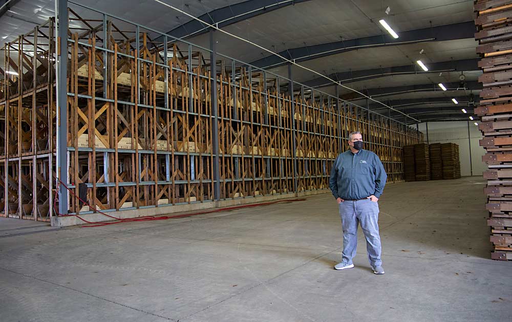 Willow Drive Nursery co-owner Jim Adams stands before an empty 26,000-square-foot warehouse in January in Ephrata, Washington, demonstrating the effect that the current economic apple slump has had on the nursery industry. (Ross Courtney/Good Fruit Grower)
