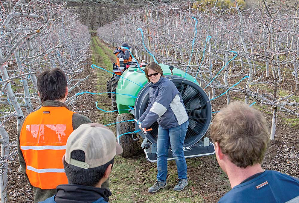 Washington State University’s Gwen Hoheisel demonstrates how flagging tape attached to each nozzle can confirm spray direction, during a March 2016 training session. Her WSU colleague, Michelle Moyer, told a Great Lakes EXPO audience that flagging tape is a good way to make sure your spray is hitting its target. (TJ Mullinax/Good Fruit Grower)