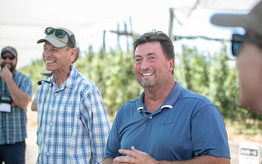 At a stop on the IFTA 2022 Summer Tour in Washington, Tom Gausman, left, and Jeff Pheasant, of AgriMACS, talk about Honeycrisp management at Monument Hill Orchards, an institutional investor-owned Honeycrisp orchard planted in 2016 in Quincy. (TJ Mullinax/Good Fruit Grower)