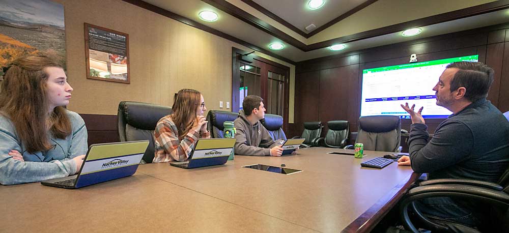 Allan Bros. Inc. Chief Financial Officer Clint Novak, right, talks with high school seniors, from left, Sarah Busey, Brooke Miles and Nathan Beauchene about the financial realities of their dream jobs after graduation. The discussion, held in January at the company’s headquarters in Naches, Washington, was part of the expansive new internship program the fruit company developed in partnership with the local school district. (TJ Mullinax/Good Fruit Grower)