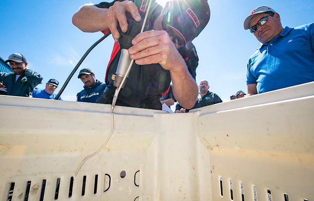 Justin Meier, application engineer from Assembly Supplies Co., teaches attendees of a bin repair workshop how to use hot-air tools to repair damaged plastic bins in Union Gap, Washington. Macro Plastics, the Union Gap manufacturer that organized the workshop, encourages bin owners to try to repair bins before tossing them or bringing them in for recycling. (TJ Mullinax/Good Fruit Grower)