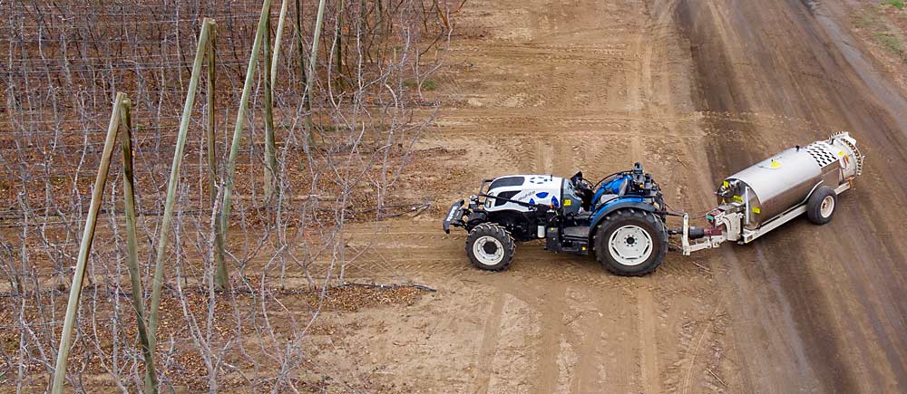 The driver’s seat is empty as the Pathfinder-equipped tractor pulls a spray tank during the demonstration. It has a typical tractor’s turning radius and can navigate challenging tree system architecture. If the sensors detect an object in the tractor’s path or periphery, the Pathfinder stops the tractor and notifies the operator. (TJ Mullinax/Good Fruit Grower)