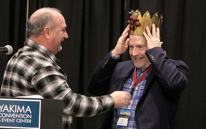 Mike Taylor of Stemilt Growers accepts the Cherry King crown from last year’s winner, Pat Sullivan. (TJ Mullinax/Good Fruit Grower)
