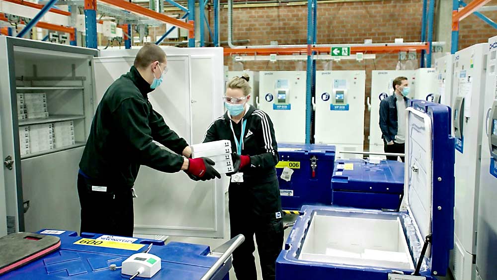Pfizer workers move the BioNTech COVID-19 vaccine into cold transport containers before it is distributed from Puurs, Belgium, in December 2020. (Courtesy Pfizer)