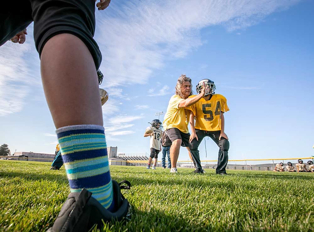 Dain Craver, the 2019 Good Fruit Grower of the Year, gives some defensive pointers to one of the third-grade players on his Royal City Grid Kids football team. Craver has been a longtime youth sports coach in his hometown. (TJ Mullinax/Good Fruit Grower)