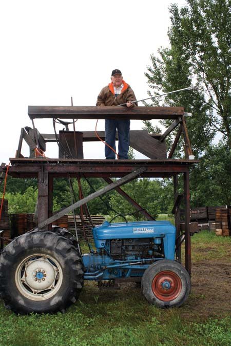Rood built this platform especially for removing fireblight strikes. Controls let him steer, brake, clutch, shift gears, and control acceleration. Shears or saw on a long pole are powered by air. (Richard Lehnert/Good Fruit Grower)