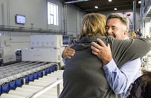 Kyle Mathison, an owner of Stemilt Growers, Inc., Wenatchee, hugs guests as they arrive to see the company's new cherry packing line.